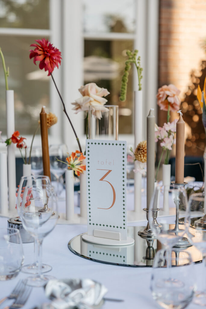 Bruiloft hotel arena amsterdam diner in patio met tubevazen en zomerse bloemstyling